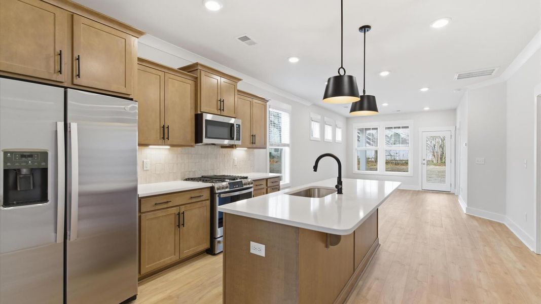 Accomplished kitchen design featuring pendant lighting above a statement island for both prep and gathering