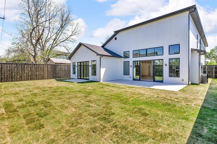 Back of property featuring a patio area, fence, and a lawn