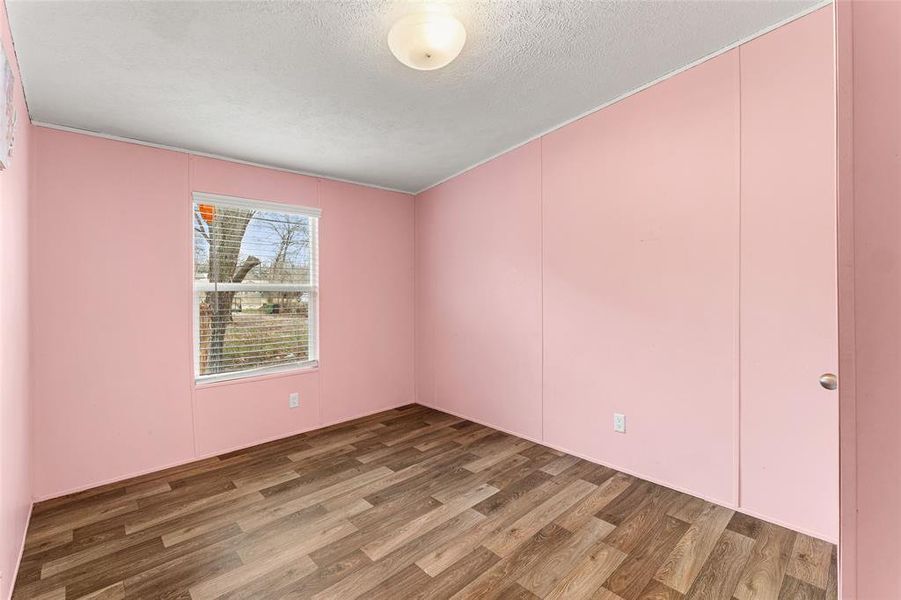 Spare room with wood finished floors and a textured ceiling