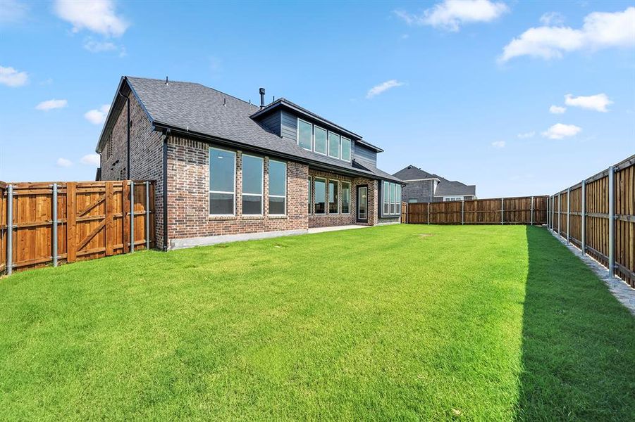 Back of property featuring a fenced backyard, a patio, brick siding, and a shingled roof