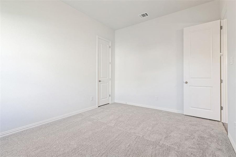 Spare room featuring baseboards and light carpet