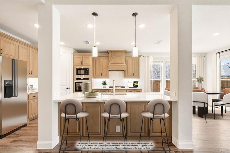 Kitchen with light wood cabinets, large island with three bar stools, pendant lights, and stainless steel appliances Kitchen with light wood cabinets, large island with three bar stools, pendant lights, and stainless steel appliances
