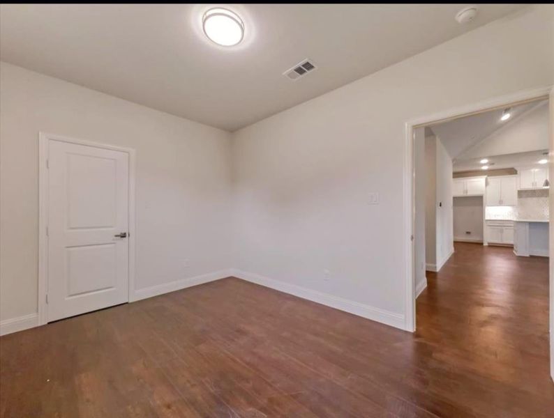 Empty room featuring dark wood-type flooring and lofted ceiling Empty room featuring dark wood-type flooring and lofted ceiling