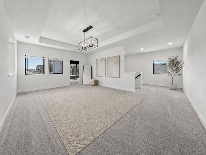 An airy secondary living area offers plush carpeting and a modern chandelier. An airy secondary living area offers plush carpeting and a modern chandelier.