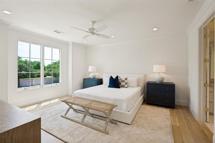 Spacious room featuring light wood-finish flooring, a large window with grid panes, recessed ceiling lighting, a ceiling fan, and crown molding
