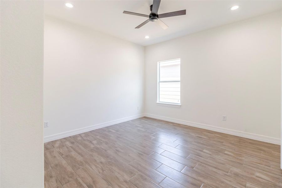 The first secondary bedroom gets the same wood-look tile, plus a ceiling fan and long walls that keep furniture placement flexible. The first secondary bedroom gets the same wood-look tile, plus a ceiling fan and long walls that keep furniture placement flexible.