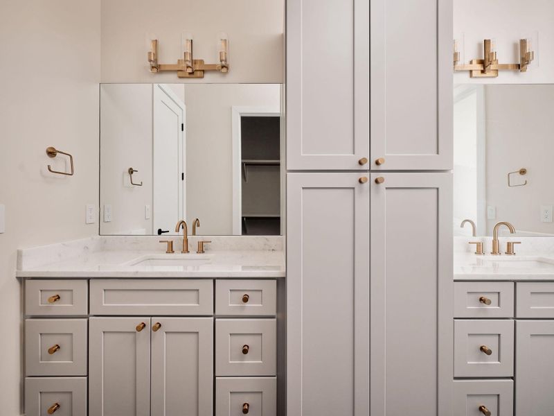 Dual vanities with sleek golden fixtures and generous cabinet storage elevate this modern bath. Dual vanities with sleek golden fixtures and generous cabinet storage elevate this modern bath.