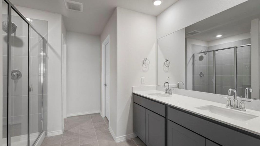 Contemporary bathroom featuring a dual vanity with a solid surface countertop, undermount sinks, and chrome faucets