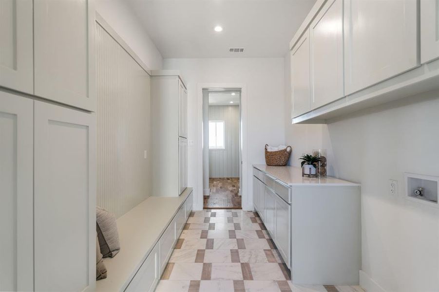 Clothes washing area featuring cabinets and hookup for a washing machine