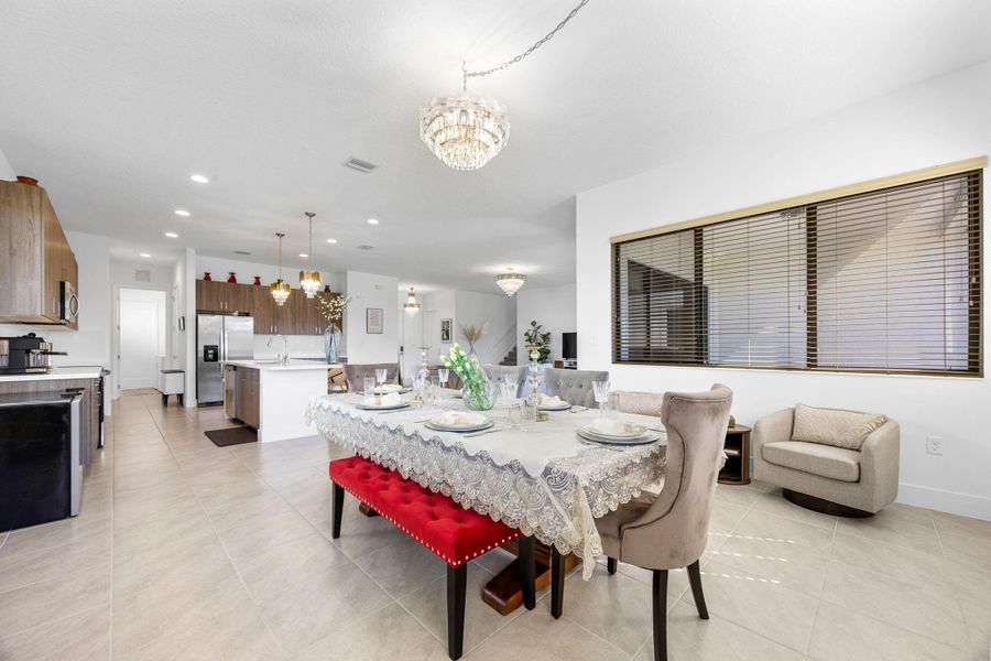 Dining area featuring a chandelier, light tile patterned floors, and recessed lighting
