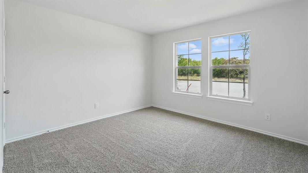 Carpeted spare room with baseboards