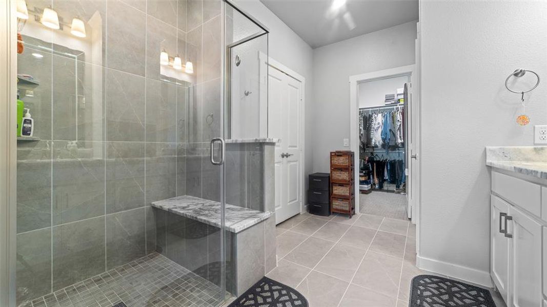 Bathroom with walk in shower, vanity, and tile floors