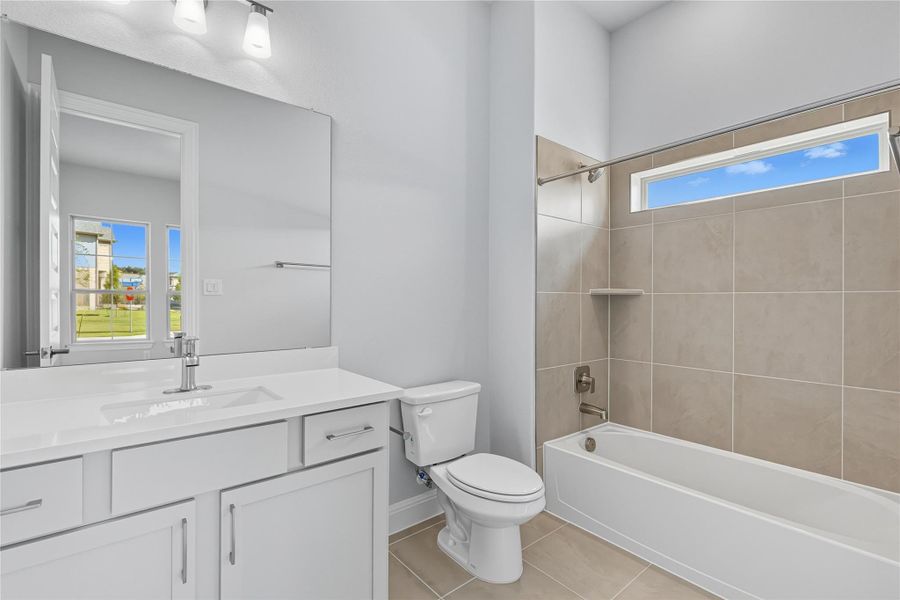 Full bath with shower / washtub combination, vanity, and light tile patterned floors Full bath with shower / washtub combination, vanity, and light tile patterned floors