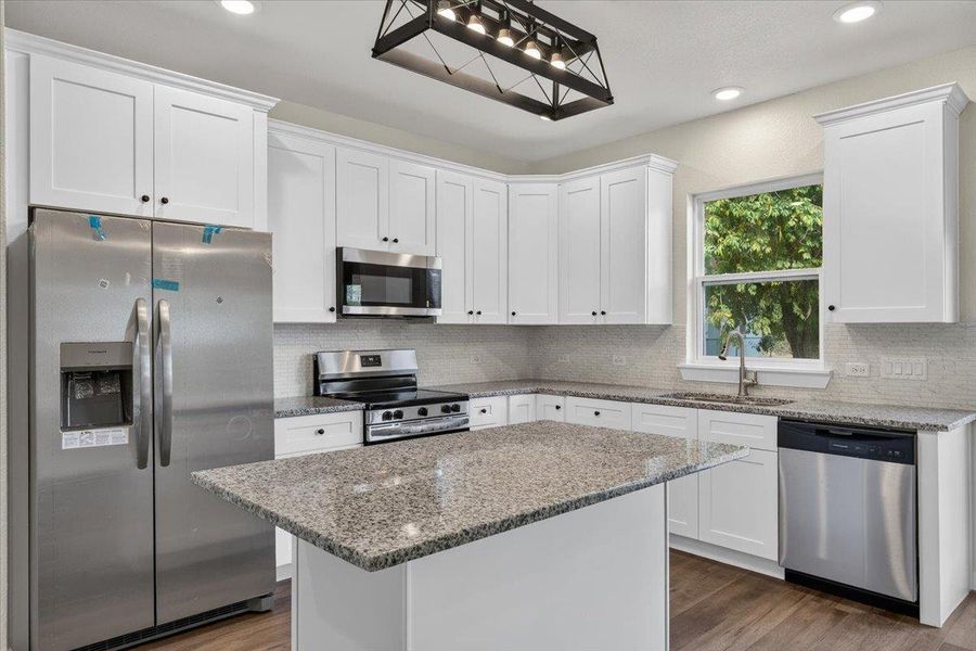 White shaker cabinetry pairs perfectly with granite countertops and a central island. White shaker cabinetry pairs perfectly with granite countertops and a central island.