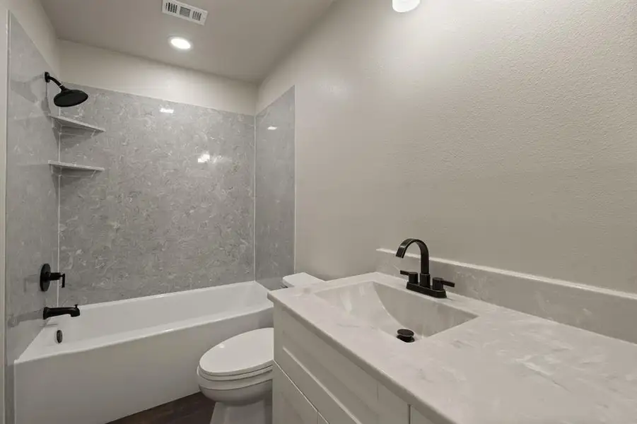 Full bath with toilet, vanity, bathtub / shower combination, wood finished floors, and recessed lighting