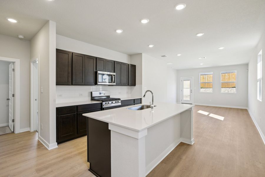 A kitchen with black cabinets.