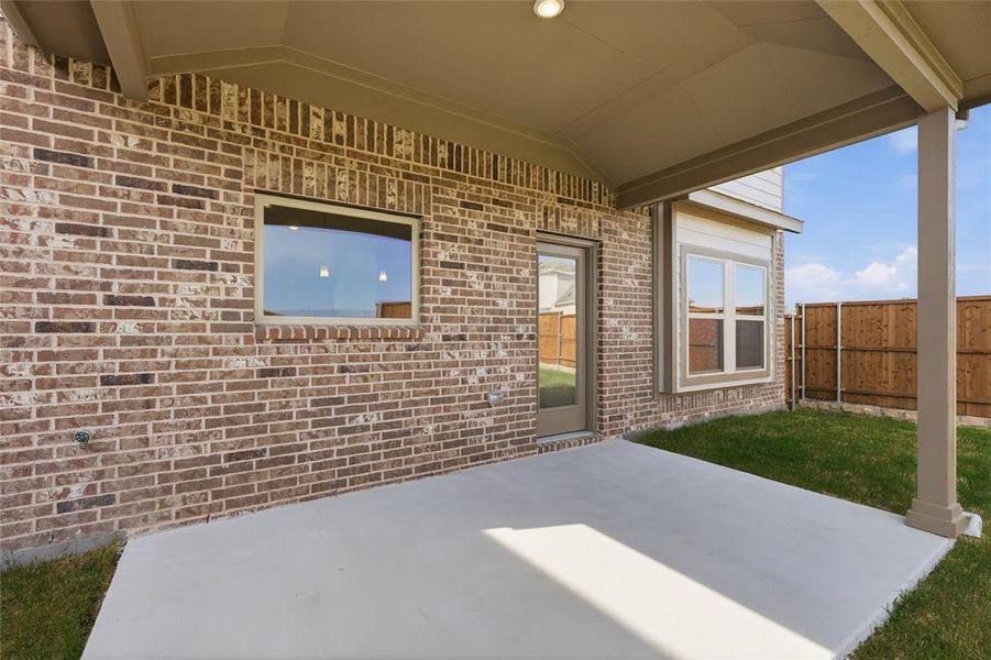 Covered patio with a concrete slab, recessed lighting, and a brick exterior