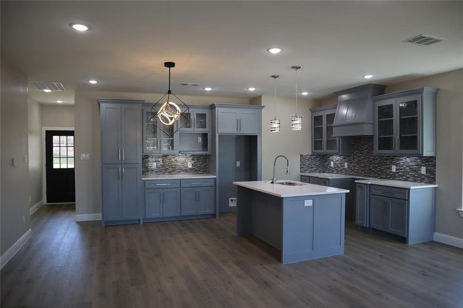 Kitchen and dining area with blue cabinetry and laminate wood flooring