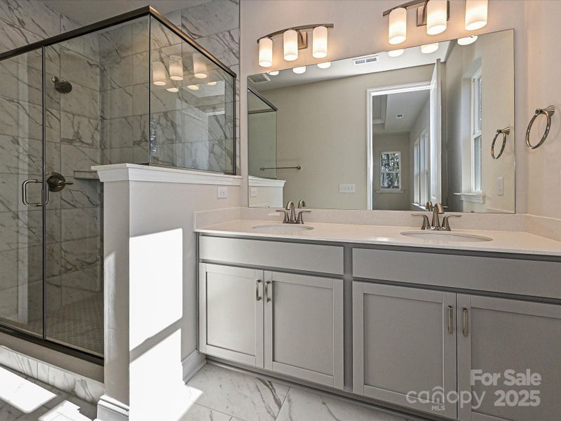 Primary En Suite Bath with Dual Vanity and Semi-Frameless Walk-In Shower. Primary En Suite Bath with Dual Vanity and Semi-Frameless Walk-In Shower.
