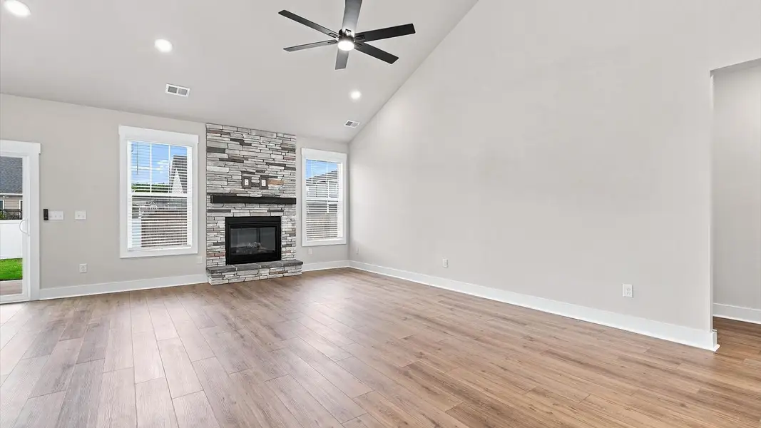 Spacious and stylish family room with two-story ceilings that create a bright and open atmosphere