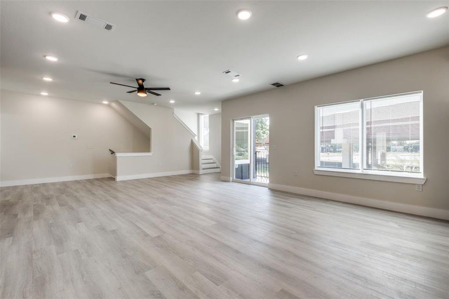 Unfurnished living room with stairway, light wood-type flooring, recessed lighting, and a ceiling fan