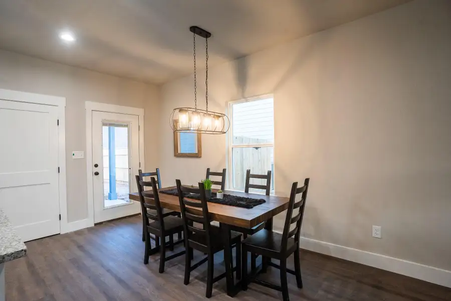 Dining space featuring dark wood-style floors, baseboards, and a chandelier Dining space featuring dark wood-style floors, baseboards, and a chandelier