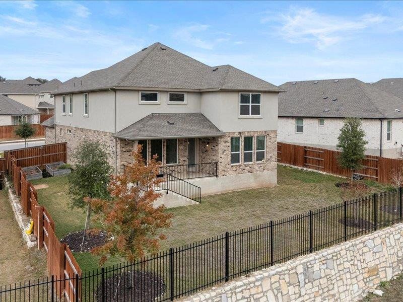 Back of property featuring a patio, stucco siding, a fenced backyard, and roof with shingles