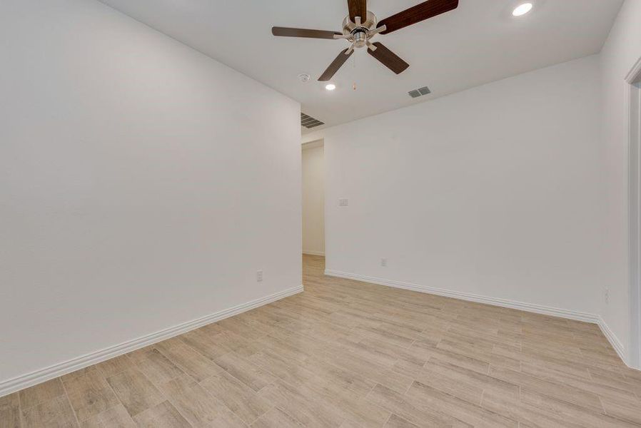 Empty room featuring ceiling fan and light hardwood / wood-style floors