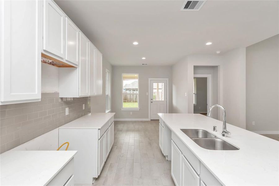 Culinary haven, featuring granite countertops, a tile backsplash, stainless steel appliances (to be installed), and 42” upper cabinets. Sample photo of completed home with similar floor plan. As-built interior colors and selections may vary