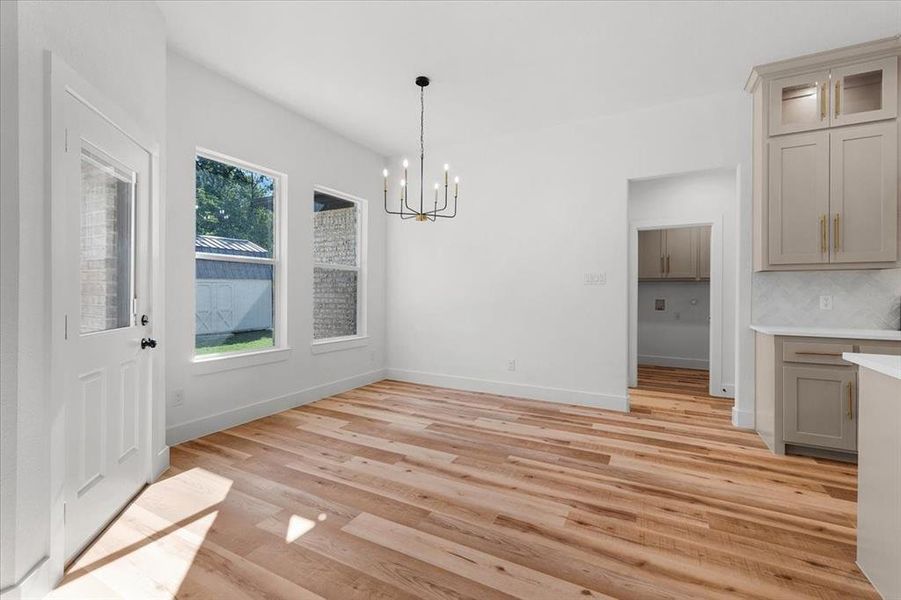 Unfurnished dining area with a notable chandelier and light wood-type flooring