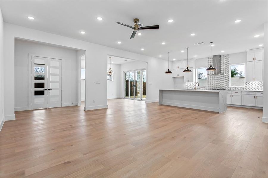 Unfurnished living room featuring sink, light wood-type flooring, and ceiling fan