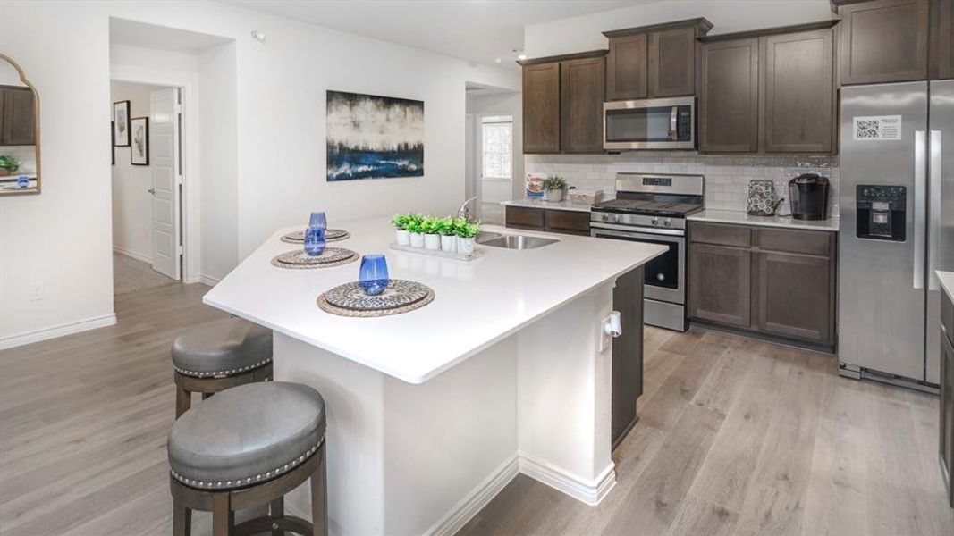 Modern kitchen featuring an angled island with a solid surface countertop and undermount sink