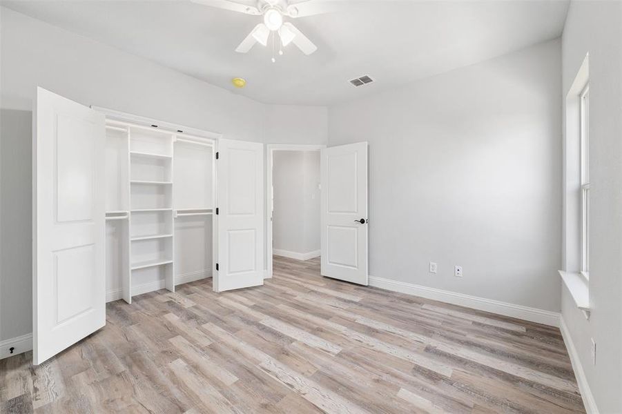 Unfurnished bedroom with light hardwood / wood-style flooring, a closet, and ceiling fan