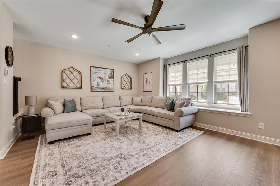 Spacious living area featuring upgraded with Pergo water tight laminate wood look flooring, recessed lighting, Levolor bottom up-top down shades, and a high end modern ceiling fan Spacious living area featuring upgraded with Pergo water tight laminate wood look flooring, recessed lighting, Levolor bottom up-top down shades, and a high end modern ceiling fan