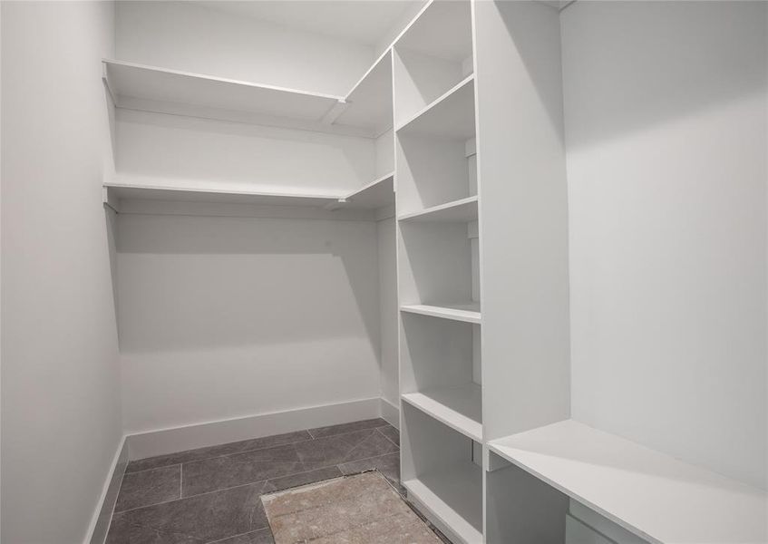 Walk in closet featuring dark tile patterned floors