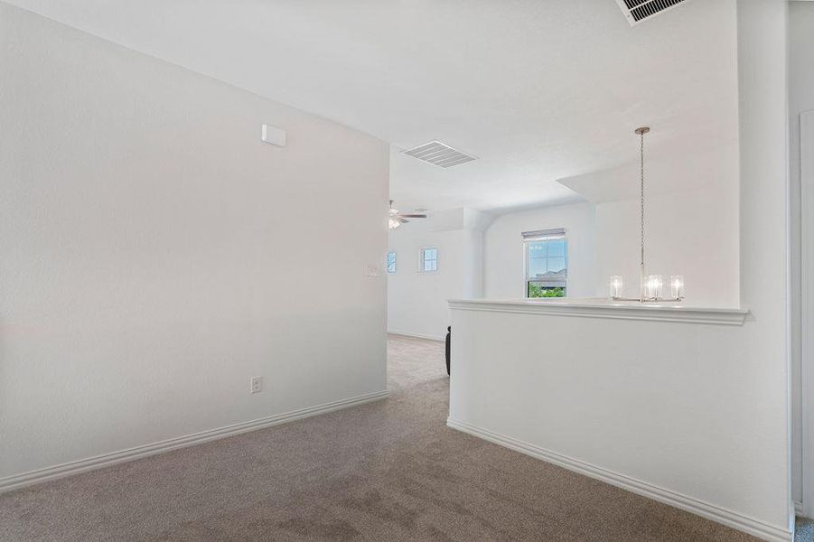 Unfurnished room featuring carpet floors, hanging lights, and a ceiling fan Unfurnished room featuring carpet floors, hanging lights, and a ceiling fan
