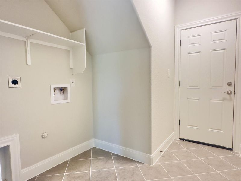 Laundry area featuring hookup for an electric dryer, hookup for a washing machine, light tile patterned flooring Laundry area featuring hookup for an electric dryer, hookup for a washing machine, light tile patterned flooring