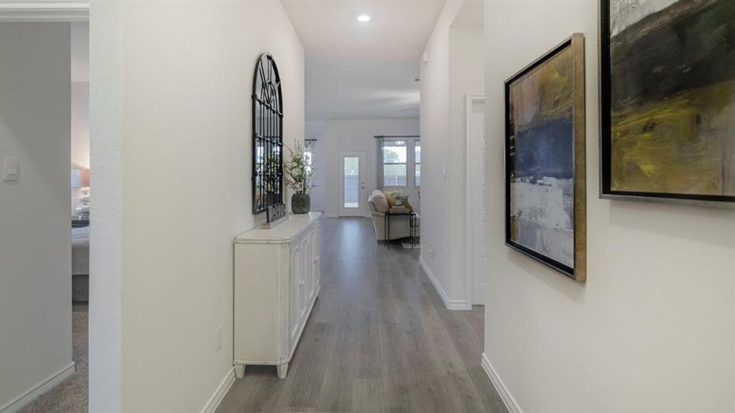 Long hallway featuring wood-finish flooring, recessed lighting, and crisp white walls