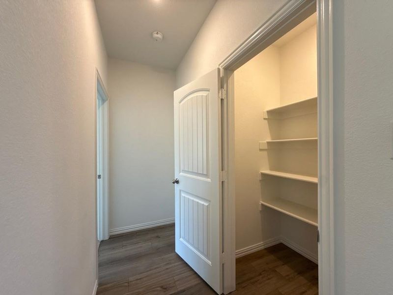 Hallway featuring dark wood-type flooring and a textured wall