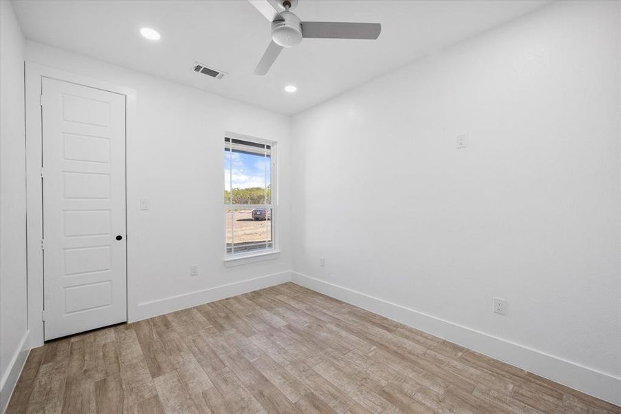 Unfurnished room with ceiling fan and light wood-type flooring