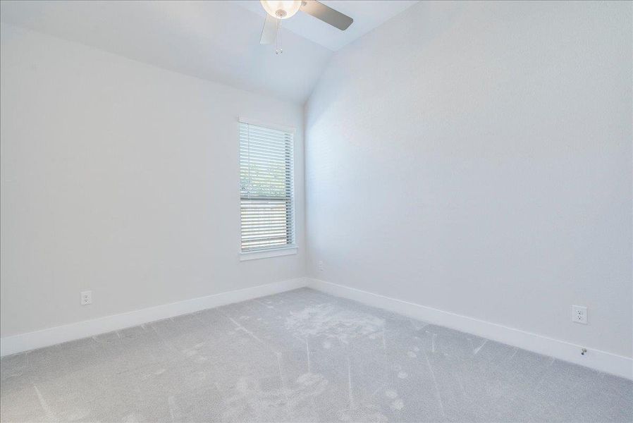 Unfurnished room with light carpet, vaulted ceiling, and ceiling fan Unfurnished room with light carpet, vaulted ceiling, and ceiling fan