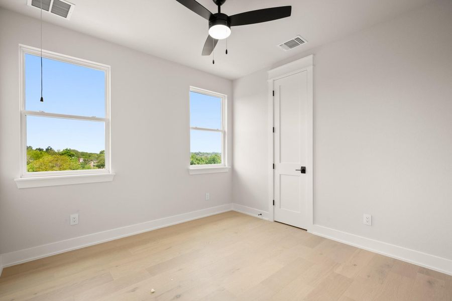 Unfurnished room featuring light wood-type flooring and ceiling fan Unfurnished room featuring light wood-type flooring and ceiling fan