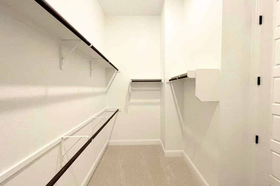 Ample built-in shelving and hanging rods maximize storage space in this carpeted closet. Ample built-in shelving and hanging rods maximize storage space in this carpeted closet.