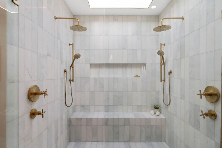 Also enjoy an amazing oversized walk-in shower nestled behind frameless glass with designer tile surround, bench seating, and dual rain shower heads and wall wands.