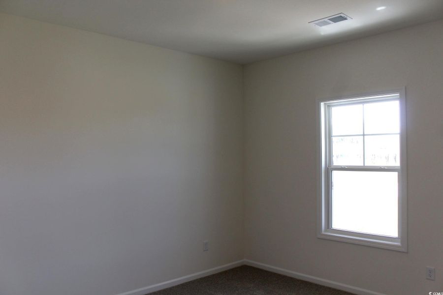 Spare room featuring baseboards and dark colored carpet Spare room featuring baseboards and dark colored carpet
