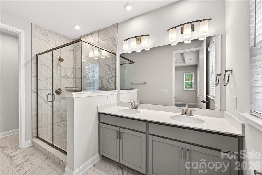 Dual vanity primary bathroom with tiled walk-in shower Dual vanity primary bathroom with tiled walk-in shower