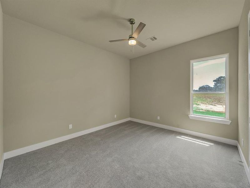 Carpeted spare room featuring ceiling fan and baseboards Carpeted spare room featuring ceiling fan and baseboards