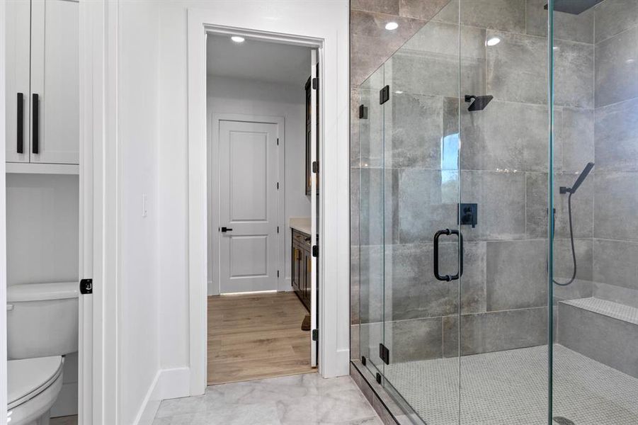 Bathroom with a shower stall, baseboards, and toilet Bathroom with a shower stall, baseboards, and toilet