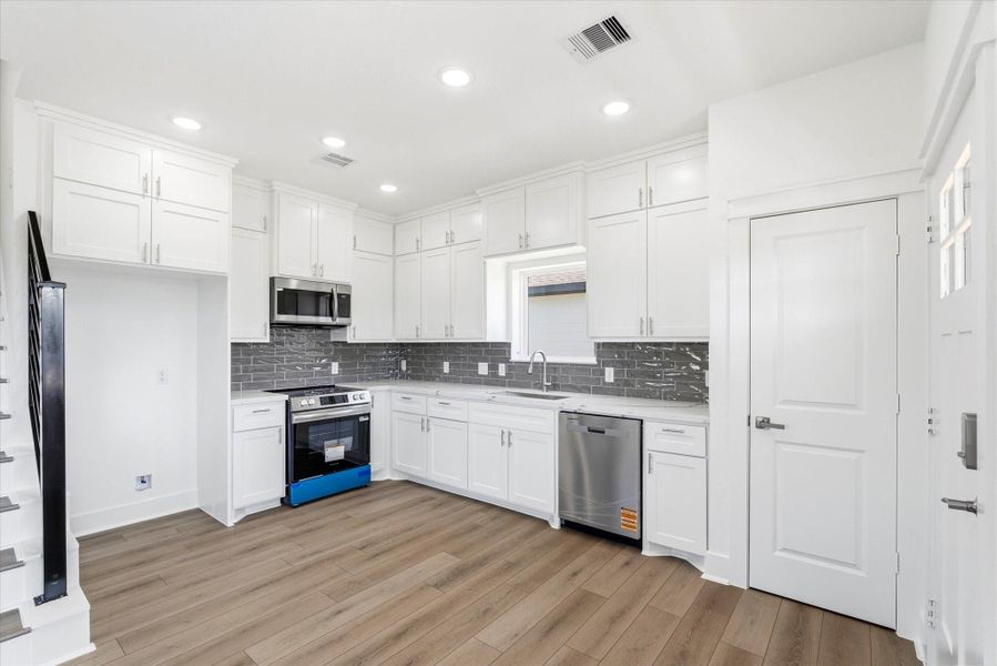 The kitchen features a subway tile backsplash, soft close cabinetry, and a full appliance package that includes the dishwasher, stove, and microwave. The refrigerator space is framed with additional cabinetry that extends to the ceiling, giving you extra storage and a clean, seamless look. Quartz countertops and silver accents tie everything together beautifully. The kitchen features a subway tile backsplash, soft close cabinetry, and a full appliance package that includes the dishwasher, stove, and microwave. The refrigerator space is framed with additional cabinetry that extends to the ceiling, giving you extra storage and a clean, seamless look. Quartz countertops and silver accents tie everything together beautifully.