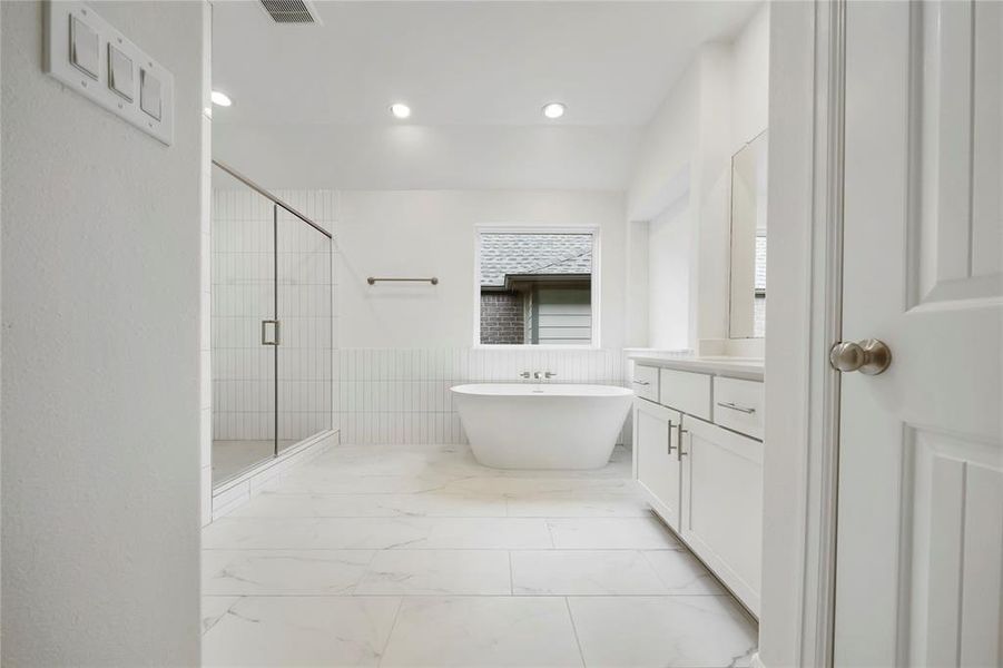 The Primary Bathroom is stunning with the stand-alone soaking tub, custom Benedettini cabinets and Moen plumbing fixtures! (Sample photos of a completed Chesapeake floor plan. The image may feature alternative selections and/or upgrades.)